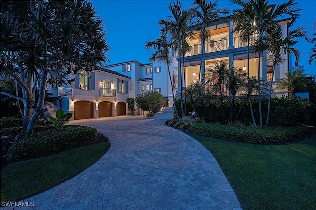 2001 4th St S, Naples, FL 34102 - mediterranean / spanish home with a balcony, an attached garage, decorative driveway, and stucco siding