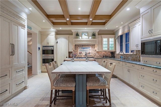 2001 4th St S, Naples, FL 34102 - kitchen with black microwave, beamed ceiling, double oven, a kitchen breakfast bar, and light stone countertops