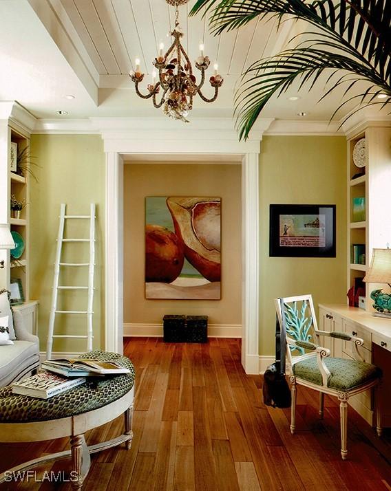 2001 4th St S, Naples, FL 34102 - living area with ornamental molding, a chandelier, hardwood / wood-style floors, and built in shelves