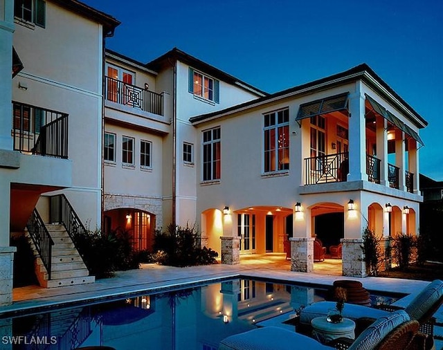 2001 4th St S, Naples, FL 34102 - back of property with a balcony, stucco siding, and stairs