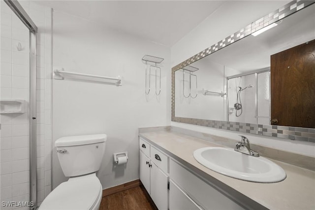 1237 SE 24th Ave Unit A, Cape Coral, FL 33990 - bathroom featuring vanity, wood finished floors, toilet, tiled shower, and baseboards