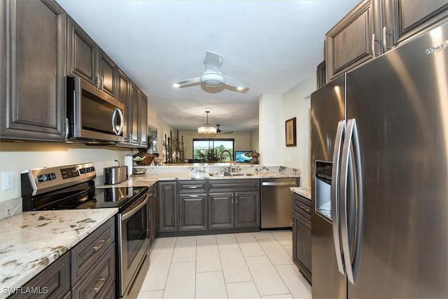12581 Kelly Sands Way Unit 525, Fort Myers, FL 33908 - kitchen with appliances with stainless steel finishes, a sink, light tile patterned floors, a ceiling fan, and light stone countertops