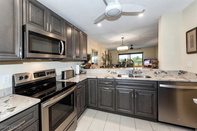 12581 Kelly Sands Way Unit 525, Fort Myers, FL 33908 - kitchen featuring stainless steel appliances, a ceiling fan, a sink, light stone counters, and light tile patterned floors