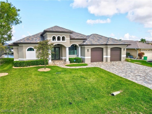 4324 SW 26th Ave, Cape Coral, FL 33914 - view of front of house featuring french doors, stucco siding, a garage, a front yard, and decorative driveway
