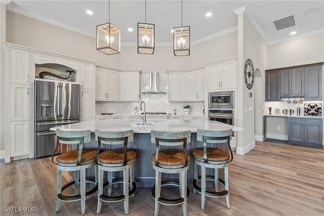 4324 SW 26th Ave, Cape Coral, FL 33914 - kitchen with appliances with stainless steel finishes, wall chimney range hood, ornamental molding, light countertops, and a kitchen bar