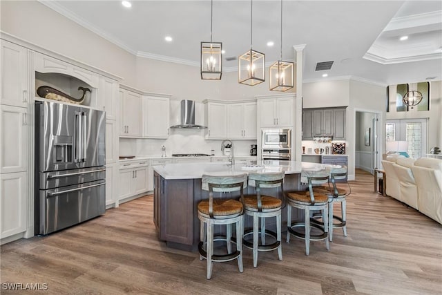 4324 SW 26th Ave, Cape Coral, FL 33914 - kitchen featuring stainless steel appliances, wall chimney exhaust hood, crown molding, a towering ceiling, and a kitchen breakfast bar