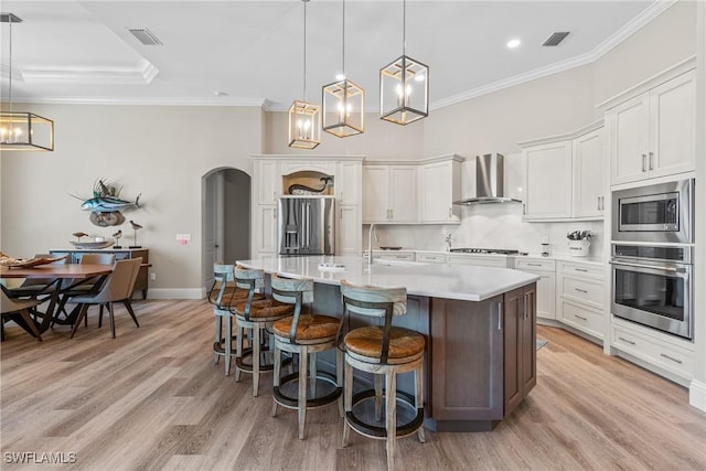 4324 SW 26th Ave, Cape Coral, FL 33914 - kitchen with stainless steel appliances, wall chimney exhaust hood, arched walkways, a breakfast bar, and light countertops