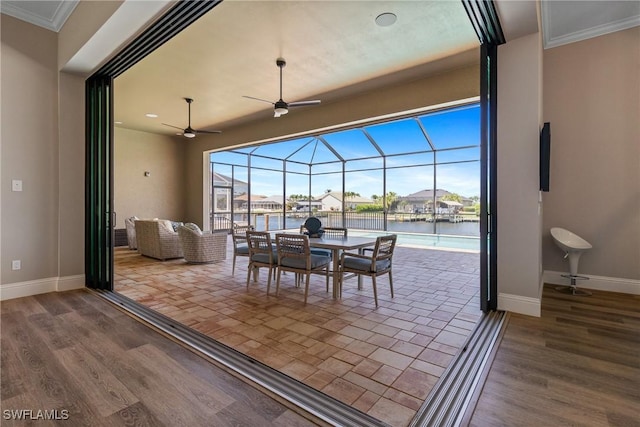 4324 SW 26th Ave, Cape Coral, FL 33914 - dining room featuring baseboards, a ceiling fan, a sunroom, a water view, and crown molding