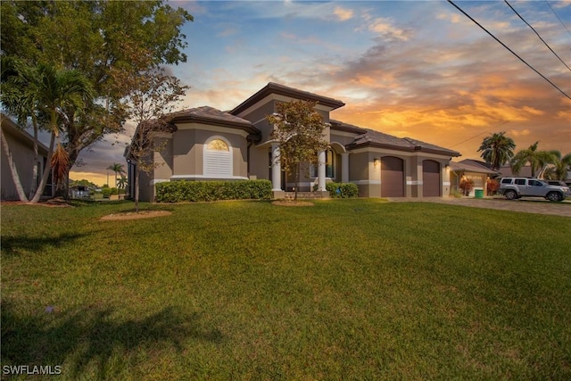 4324 SW 26th Ave, Cape Coral, FL 33914 - mediterranean / spanish house featuring a garage, a yard, driveway, and stucco siding