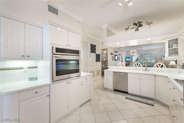14550 Red Fox Run Unit 407, Naples, FL 34110 - kitchen with stainless steel appliances, ceiling fan, white cabinetry, light countertops, and lofted ceiling
