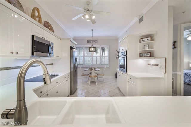 14550 Red Fox Run Unit 407, Naples, FL 34110 - kitchen with appliances with stainless steel finishes, white cabinets, ornamental molding, ceiling fan, and hanging light fixtures