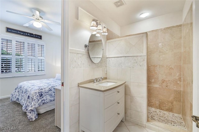14550 Red Fox Run Unit 407, Naples, FL 34110 - bathroom with vanity, walk in shower, a ceiling fan, tile walls, and ensuite bath