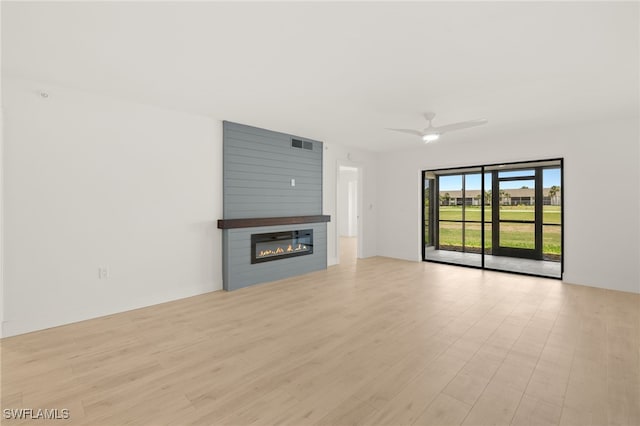 16260 Kelly Cove Dr Unit 235, Fort Myers, FL 33908 - unfurnished living room with a fireplace, ceiling fan, and light wood-style floors