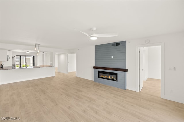 16260 Kelly Cove Dr Unit 235, Fort Myers, FL 33908 - unfurnished living room featuring ceiling fan, light wood finished floors, and a large fireplace