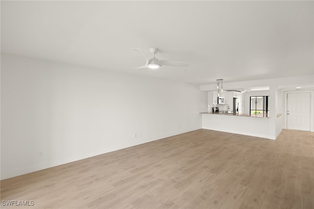 16260 Kelly Cove Dr Unit 235, Fort Myers, FL 33908 - unfurnished living room featuring a ceiling fan, light wood-style flooring, and a sink