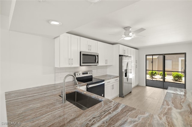 16260 Kelly Cove Dr Unit 235, Fort Myers, FL 33908 - kitchen featuring stainless steel appliances, a sink, light stone countertops, tasteful backsplash, and white cabinetry