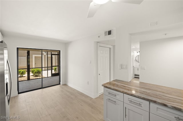 16260 Kelly Cove Dr Unit 235, Fort Myers, FL 33908 - kitchen with stainless steel refrigerator with ice dispenser, light wood finished floors, ceiling fan, light stone countertops, and baseboards