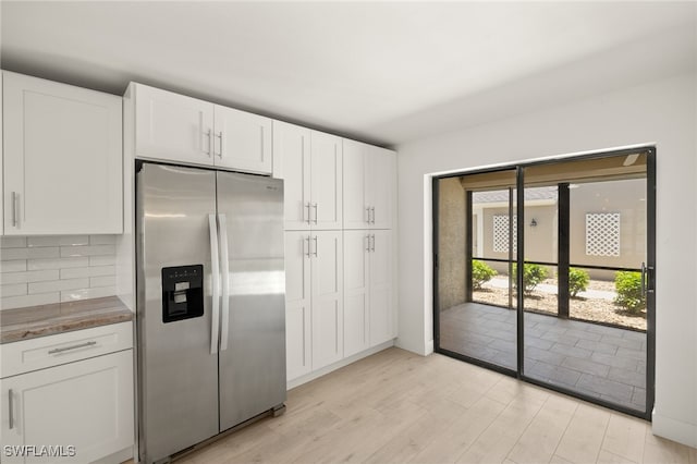 16260 Kelly Cove Dr Unit 235, Fort Myers, FL 33908 - kitchen with stainless steel fridge with ice dispenser, white cabinetry, light wood finished floors, and backsplash
