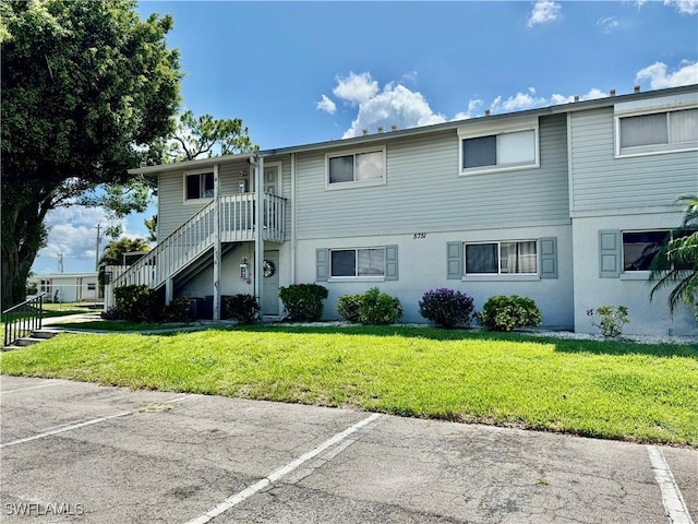 5751 Foxlake Dr Unit A, North Fort Myers, FL 33917 - view of building exterior featuring uncovered parking and stairway