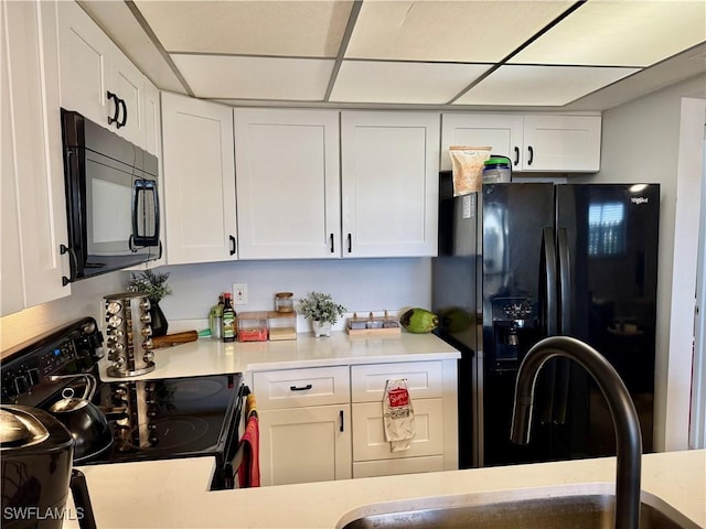 5751 Foxlake Dr Unit A, North Fort Myers, FL 33917 - kitchen featuring black appliances, white cabinets, light countertops, a sink, and a drop ceiling
