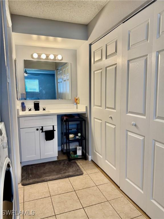 5751 Foxlake Dr Unit A, North Fort Myers, FL 33917 - bathroom featuring vanity, washer / dryer, and tile patterned flooring