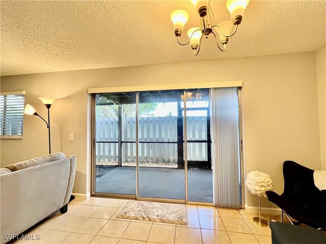 5751 Foxlake Dr Unit A, North Fort Myers, FL 33917 - living area featuring a chandelier, a textured ceiling, light tile patterned floors, and baseboards