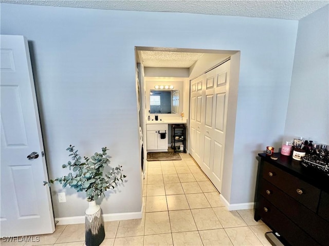 5751 Foxlake Dr Unit A, North Fort Myers, FL 33917 - corridor with light tile patterned flooring, baseboards, and a textured ceiling
