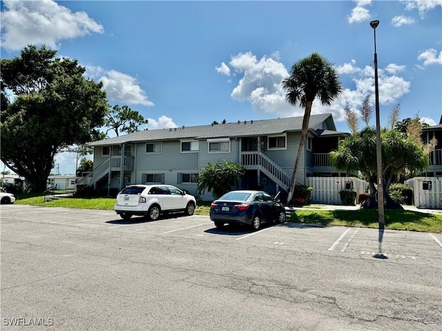 5751 Foxlake Dr Unit A, North Fort Myers, FL 33917 - view of building exterior with stairs and uncovered parking