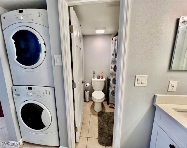 5751 Foxlake Dr Unit A, North Fort Myers, FL 33917 - washroom with stacked washer and clothes dryer and light tile patterned floors