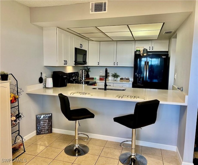 5751 Foxlake Dr Unit A, North Fort Myers, FL 33917 - kitchen with black appliances, a peninsula, a sink, and a breakfast bar