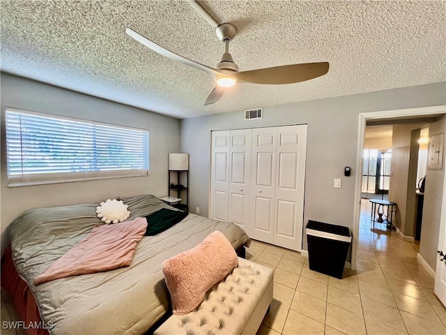 5751 Foxlake Dr Unit A, North Fort Myers, FL 33917 - bedroom featuring light tile patterned floors, multiple windows, a closet, a textured ceiling, and ceiling fan