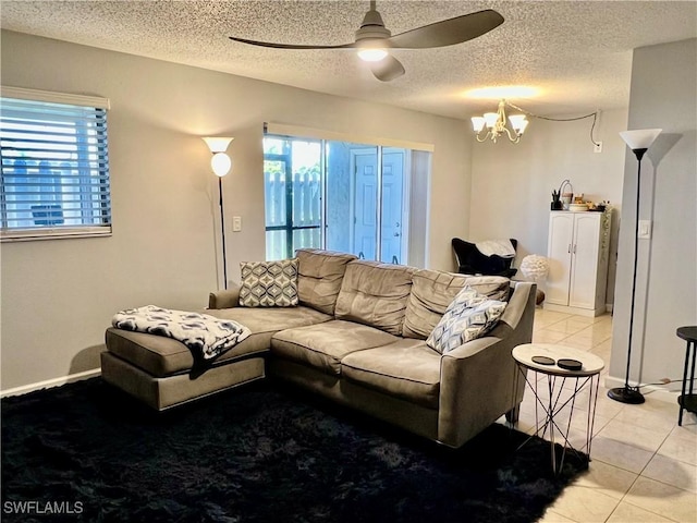 5751 Foxlake Dr Unit A, North Fort Myers, FL 33917 - living room featuring plenty of natural light, ceiling fan, light tile patterned flooring, a chandelier, and a textured ceiling