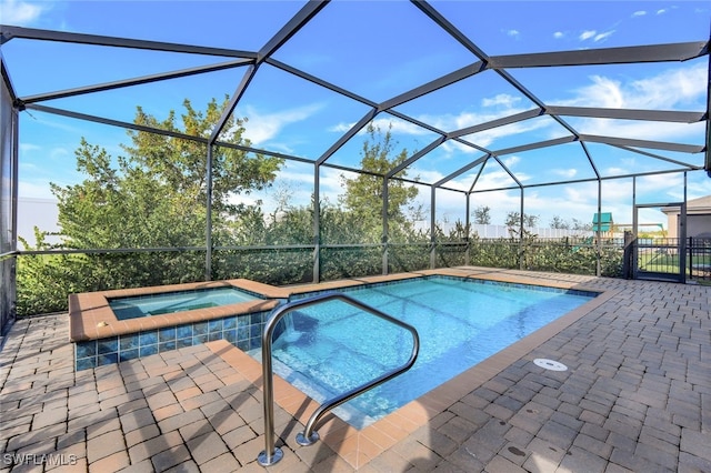14498 Cantabria Dr, Fort Myers, FL 33905 - view of swimming pool with a patio area, glass enclosure, and a pool with connected hot tub