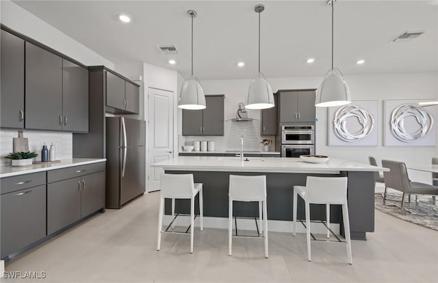 12412 Basalt Ln, Alva, FL 33982 - kitchen with appliances with stainless steel finishes, a kitchen breakfast bar, backsplash, and recessed lighting