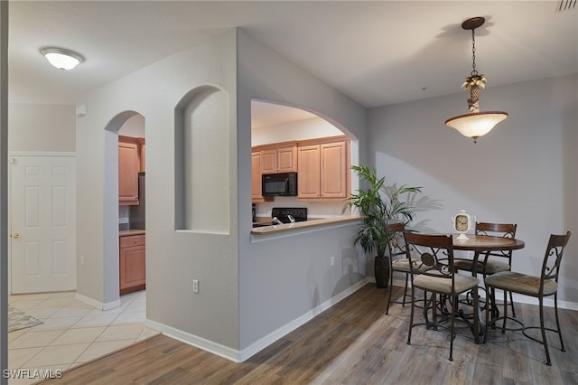 4381 Lazio Way Unit 504, Fort Myers, FL 33901 - dining area with arched walkways, light wood finished floors, and baseboards