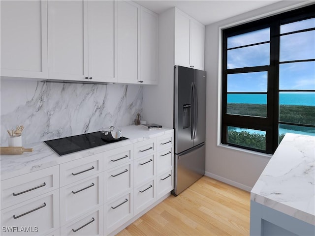 440 Seaview Ct Unit 1012, Marco Island, FL 34145 - kitchen with stainless steel refrigerator with ice dispenser, backsplash, light wood-style flooring, black electric cooktop, and light stone countertops