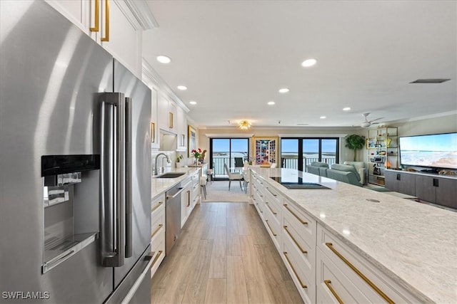 1100 S Collier Blvd Unit 1025, Marco Island, FL 34145 - kitchen with stainless steel appliances, a sink, white cabinets, recessed lighting, and ornamental molding