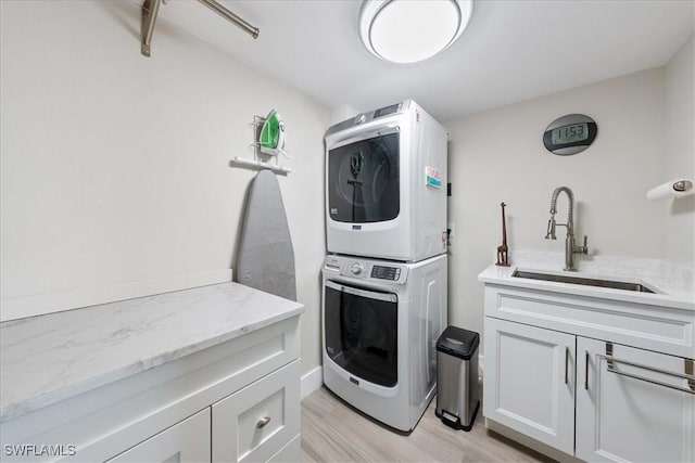 1100 S Collier Blvd Unit 1025, Marco Island, FL 34145 - laundry room with stacked washer / dryer, cabinet space, and light wood-type flooring