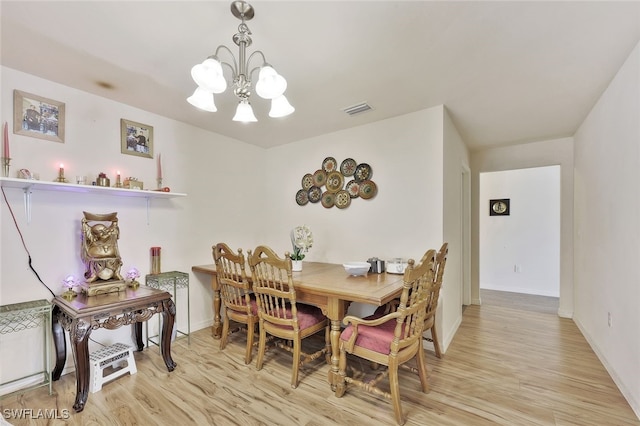 4326 SW 9th Ave, Cape Coral, FL 33914 - dining space with a chandelier, light wood finished floors, and baseboards
