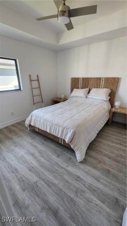 702 NW 30th Pl, Cape Coral, FL 33993 - bedroom featuring wood finished floors, ceiling fan, and baseboards