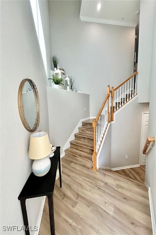 3153 Aviamar Cir Unit 202, Naples, FL 34114 - staircase featuring wood finished floors, ornamental molding, and baseboards