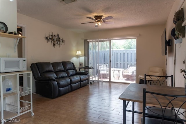1165 Palm Ave Unit 8A, North Fort Myers, FL 33903 - living area with ceiling fan, wood finished floors, and a textured ceiling