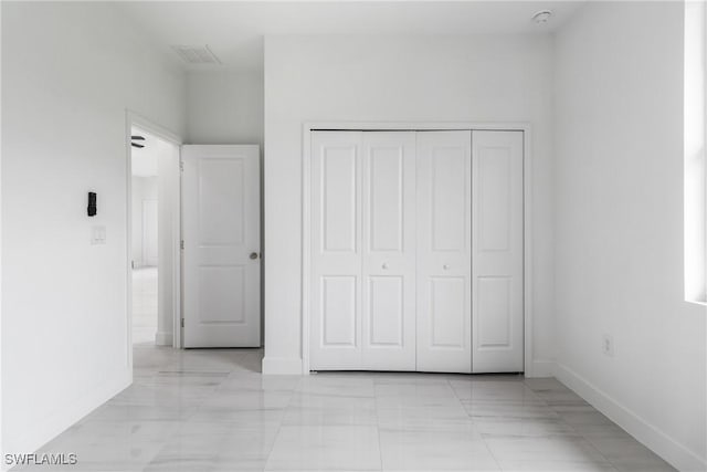 2605 Darlene Pl, Lehigh Acres, FL 33971 - unfurnished bedroom with baseboards, a closet, and light marble finish floors