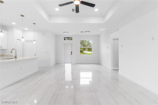2605 Darlene Pl, Lehigh Acres, FL 33971 - unfurnished living room featuring a sink, ceiling fan, a tray ceiling, recessed lighting, and baseboards