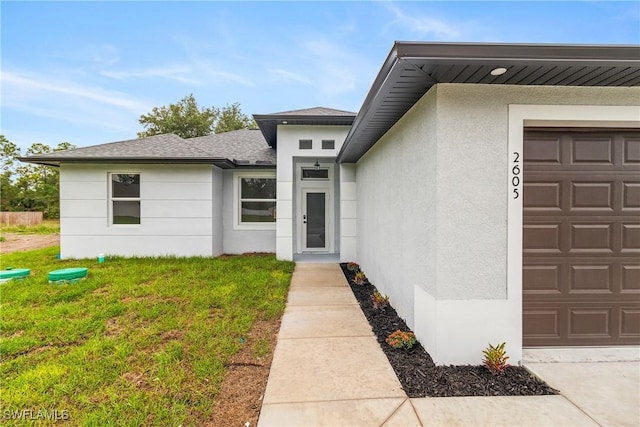 2605 Darlene Pl, Lehigh Acres, FL 33971 - doorway to property with a garage, stucco siding, a yard, and roof with shingles