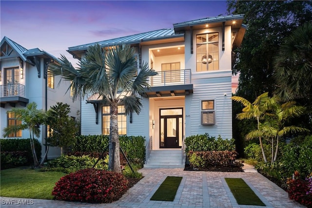 845 11th Ave S, Naples, FL 34102 - view of front of home with a balcony, a standing seam roof, metal roof, and stucco siding