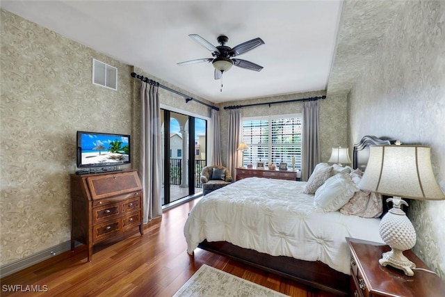 23159 Amgci Way Unit 302, Estero, FL 33928 - bedroom featuring wood finished floors, wallpapered walls, access to exterior, and ceiling fan