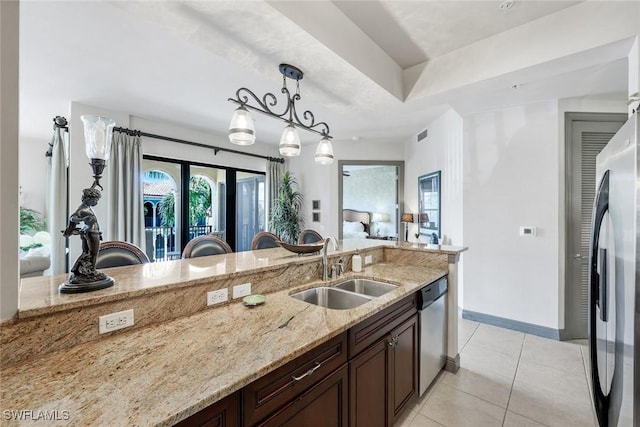 23159 Amgci Way Unit 302, Estero, FL 33928 - kitchen with a sink, stainless steel appliances, light stone counters, pendant lighting, and dark brown cabinetry