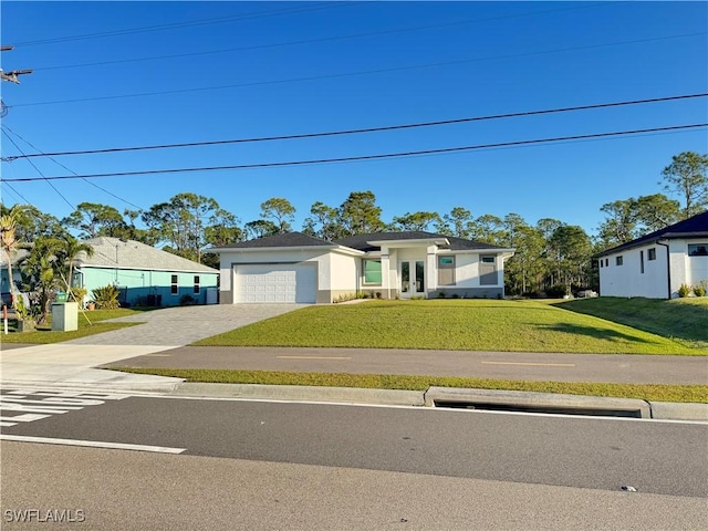 2933 Van Buren Pkwy, Cape Coral, FL 33993 - view of front of property featuring decorative driveway, a garage, a front lawn, french doors, and stucco siding