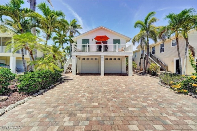 291 Mango St, Fort Myers Beach, FL 33931 - coastal home with stairs, decorative driveway, and an attached garage